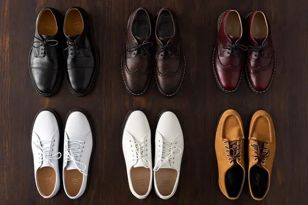 Flat lay of men's shoes: oxfords, brogues, loafers, chelsea boots and sneakers